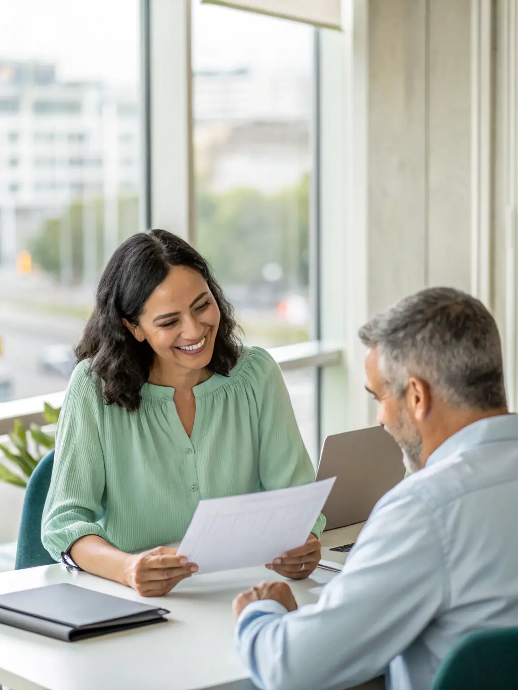 A health insurance agent is confidently shaking hands with a new client in a modern office setting, representing successful lead conversion.